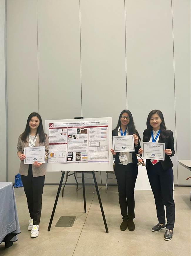 Peiyi, Raissa, and Dr. Song standing in front of their poster and holding the Best Poster Award.